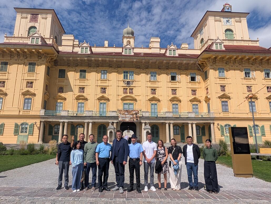 Gruppe vor Schloss Hof in Niederösterreich mit Blick auf das barocke Gebäude im Hintergrund.